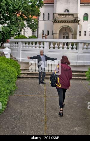 Un homme attend avec joie son chéri devant l'entrée du château. Il ne cache pas ses émotions. Banque D'Images