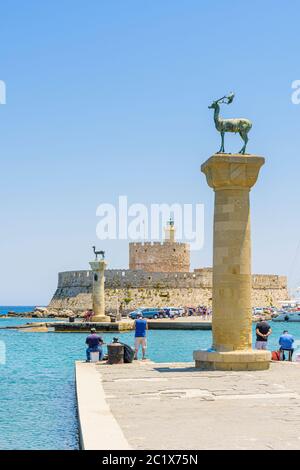 Statues de cerfs de bronze et forteresse Saint-Nicolas à l'entrée du port de Mandraki, ville de Rhodes, île de Rhodes, Grèce Banque D'Images