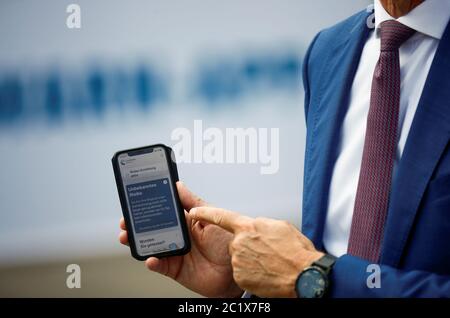 Berlin, Allemagne. 16 juin 2020. Timothée Höttges, PDG du géant allemand des télécommunications Deutsche Telekom AG, récupère un smartphone lors de la présentation de l'application d'avertissement corona officielle dans sa main, sur laquelle est présentée l'application d'avertissement corona officielle. Le gouvernement allemand compte sur une large utilisation volontaire de la nouvelle application d'avertissement contre le nouveau virus corona. Crédit: Hannibal Hanschke/Reuters Pool/dpa/Alay Live News Banque D'Images