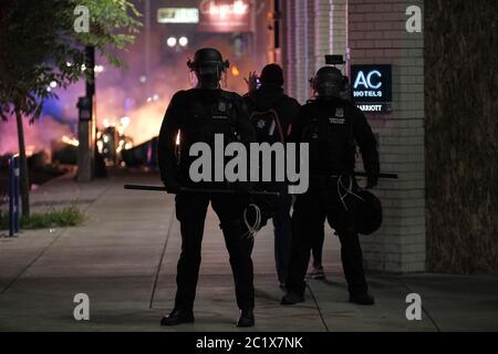 Portland, États-Unis. 15 juin 2020. Un personnel de presse est autorisé derrière une ligne de police tandis que les officiers bloquent la rue tandis que des poubelles brûlent sur Southwest 3rd et Taylor pendant la dix-huitième nuit de manifestations contre la brutalité de la police à Portland, Ore., le 15 juin 2020. (Photo par Alex Milan Tracy/Sipa USA) crédit: SIPA USA/Alay Live News Banque D'Images