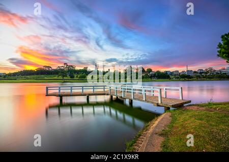 Lever du soleil sur le petit pont surplombant le lac avec le ciel dramatique accueille une nouvelle journée dans la ville touristique du Vietnam Banque D'Images