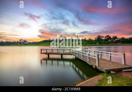 Lever du soleil sur le petit pont surplombant le lac avec le ciel dramatique accueille une nouvelle journée dans la ville touristique du Vietnam Banque D'Images