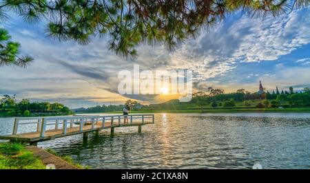 Lever du soleil sur le petit pont surplombant le lac avec le ciel dramatique accueille une nouvelle journée dans la ville touristique du Vietnam Banque D'Images