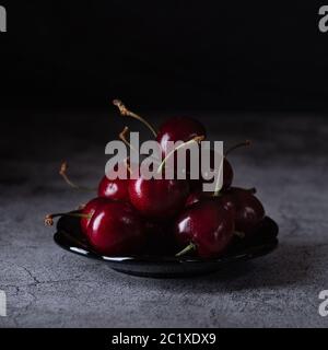 Cerise rouge dans l'obscurité sur la table Banque D'Images