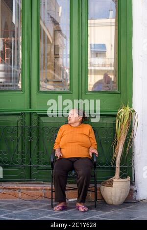 Femme âgée assise devant une maison, Plaza Vieja, place de la Vieille, la Havane Vieja, la Havane, Cuba Banque D'Images
