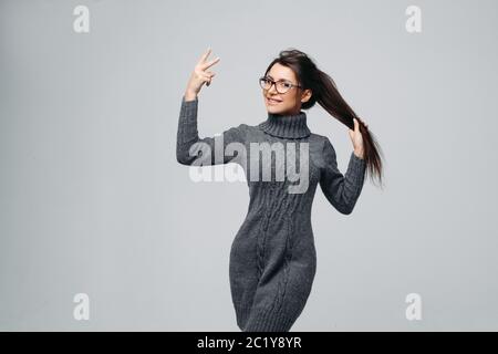 Brunette mignon joyeux dans les verres montrant signe de paix Banque D'Images