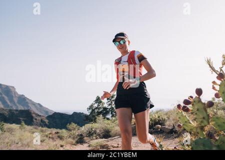 Femme court à travers le pays sur un chemin de montagne à l'île des Canaries Banque D'Images