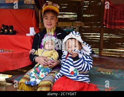 Femme thaïlandaise Kayan à col long (femme girafe) avec deux enfants. Banque D'Images