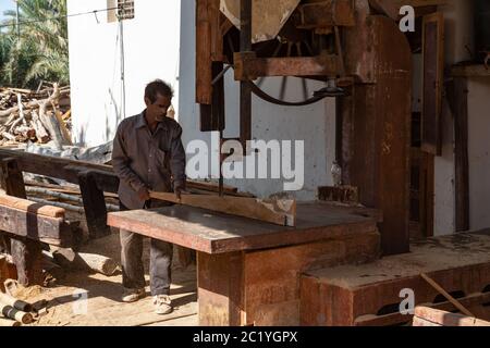 Sur, Oman - novembre 27 2019 un travailleur sciant des planches de navires dans le quai traditionnel de dhow à sur, Oman Banque D'Images