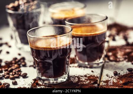 Café turc noir dans des tasses en verre et des grains de café renversés Banque D'Images