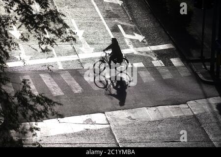 Vue de dessus d'un motard silhouetté traversant la route Banque D'Images