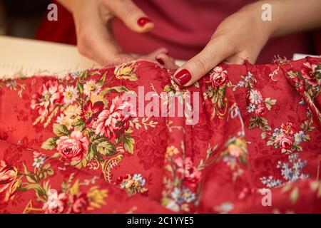 tailleur femme ragoûts robe rouge. Travailler sur mesure dans son atelier de travail sur mesure Banque D'Images