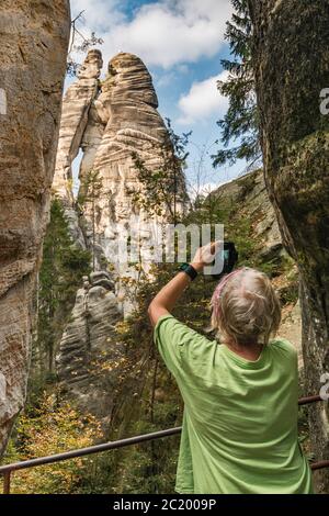 Femme senior randonneur chez Lovers (Milenci), flèches de grès à Adršpach Rocks, Réserve naturelle nationale des rochers Adršpach-Teplice, Central Sudètes, République tchèque Banque D'Images