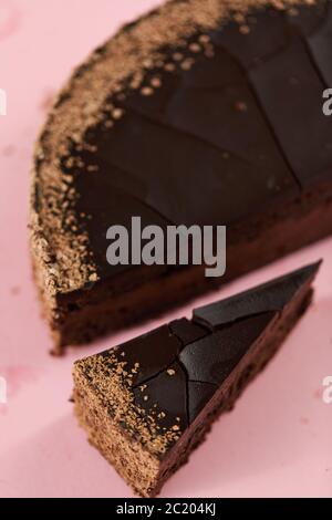 délicieux gâteau au chocolat maison avec morceau de coupe sur fond rose Banque D'Images