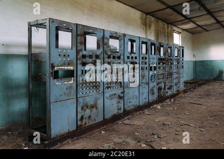 Armoires de commutation électriques cassées avec panneaux de commande en usine abandonnée. Banque D'Images