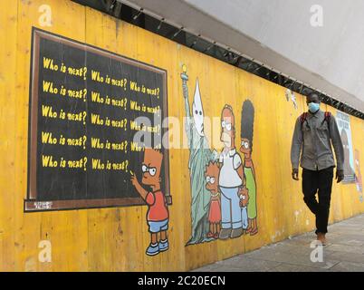 Milan, Italie. 16 juin 2020. Italie, Milan Alexandro Palombo Street artiste de nouvelles peintures murales à Milan intitulé "juste parce que je suis Noir" en mémoire de la mort de George Floyd qui représente la famille Simpson avec la peau noire et à côté de la statue de la liberté avec la cape de la Ku Klux Klan Nella photo: Travailler avec les Simpsons et portrait de George Floyd crédit: Agence de photo indépendante/Alamy Live News Banque D'Images