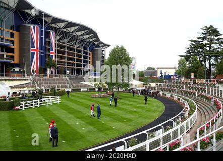 Des jockeys attendent de monter leurs chevaux dans l'anneau de parade avant les piquets du King's Stand pendant le premier jour de l'Ascot royale à l'hippodrome d'Ascot. Banque D'Images