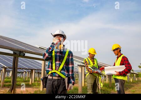 L'électricien en ingénierie travaillant dans la ferme de cellules solaires Banque D'Images