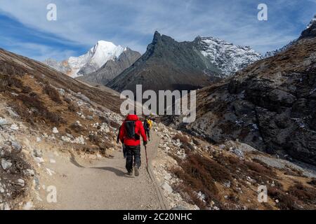 Le voyageur qui se rend à pied à la chaîne de montagnes enneigées de la réserve naturelle de Yading en Chine. Banque D'Images