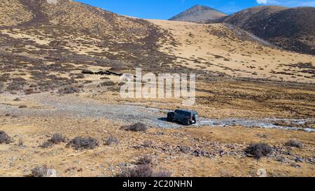 Groupe voyageant avec une voiture tout-terrain dans la prairie du Yunnan, Chine. Banque D'Images