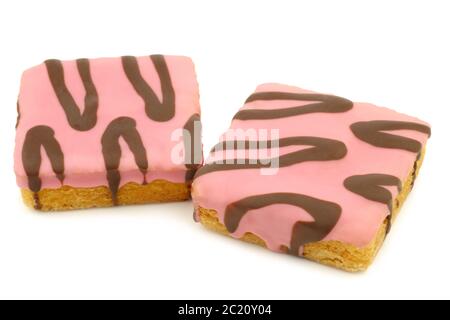 gâteaux carrés fraîchement cuits, vernis rose, avec sauce au chocolat sur fond blanc Banque D'Images