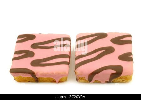 gâteaux carrés fraîchement cuits, vernis rose, avec sauce au chocolat sur fond blanc Banque D'Images