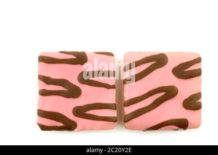 gâteaux carrés fraîchement cuits, vernis rose, avec sauce au chocolat sur fond blanc Banque D'Images