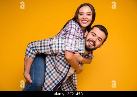 Portrait de gaies et passionnés conjoints homme porte femme portier appréciez le repos d'été détente porter ensemble à carreaux isolé sur la couleur brillante Banque D'Images