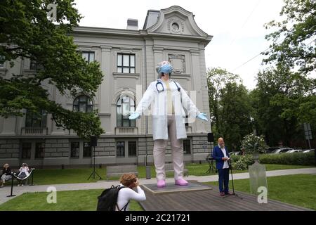 Riga, Lettonie. 15 janvier 2012. Une femme photographie la statue « les acteurs du monde » du sculpteur Aigars Bikse devant le Musée national d'art de Lettonie comme un signe de gratitude et d'appréciation pour les efforts désintéressés des médecins et des infirmières pendant la pandémie de Corona. Elle montre un médecin portant un protège-bouche et des gants, qui a quitté la salle de traitement et s'étire avec ses yeux fermés pour se préparer à sa prochaine tâche. Credit: Alexander Welscher/dpa/Alay Live News Banque D'Images