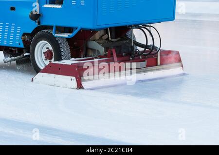 préparation de glace à la patinoire publique entre les séances en soirée à l'extérieur. Glace polie prête pour le match. Machine d'entretien de la glace - fermeture Banque D'Images