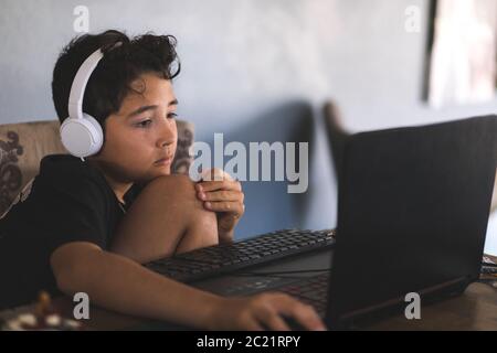 Garçon qui fait ses devoirs sur un ordinateur portable Banque D'Images