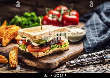 Haricots hachés pain végan avec laitue, tomate et concombre, quartiers de pommes de terre et mayonnaise Banque D'Images