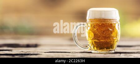 Tasse à bière avec bière pression fraîche sur une table d'extérieur Banque D'Images