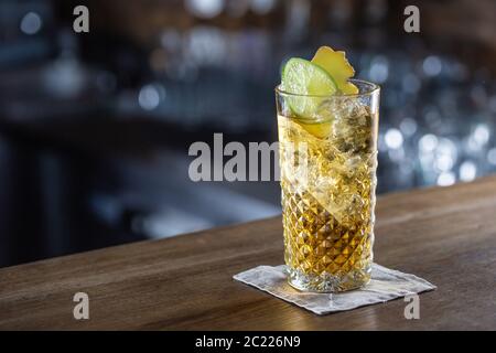 Limonade au Bourbon et au gingembre servie avec de la glace dans un verre sur un bar Banque D'Images