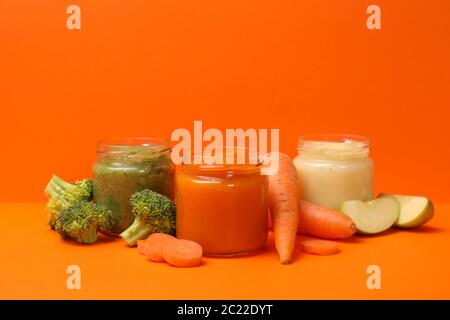 Composition avec purée de légumes sur fond orange. Nourriture pour bébé Banque D'Images
