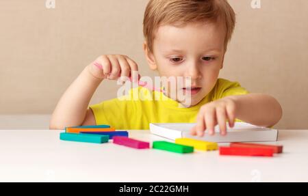 Blanc bébé blond sculpte de la pâte pour enfants pour sculpter à la maison à la table, les enfants et la créativité, le développement de fines compétences motrices Banque D'Images