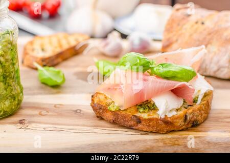 Crostini avec jambon forêt noire, fromage Parmesan et pesto au basilic Banque D'Images