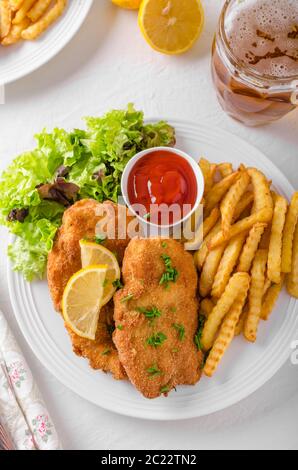 Wiener Schnitzel avec frites, salade et une forte baisse Banque D'Images