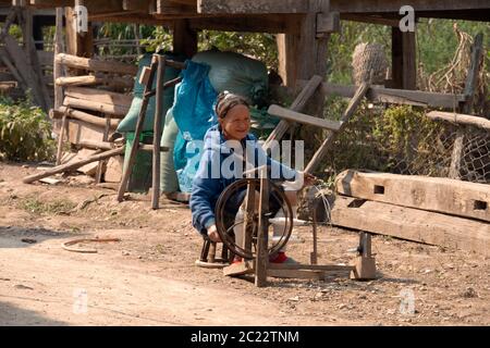 Une femme Lanten, âgée, indigène et ethnique, filant dans son village de la province de Luang Namtha, dans le nord du Laos. Banque D'Images