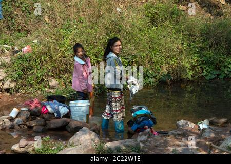 Des villageois autochtones de Lanten faisant leur lessive dans un ruisseau de leur village dans la province de Luang Namtha, au nord du Laos. Banque D'Images