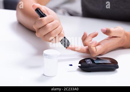 Close-up of a Woman's Hand Testing le haut sucre de sang avec diabete Banque D'Images