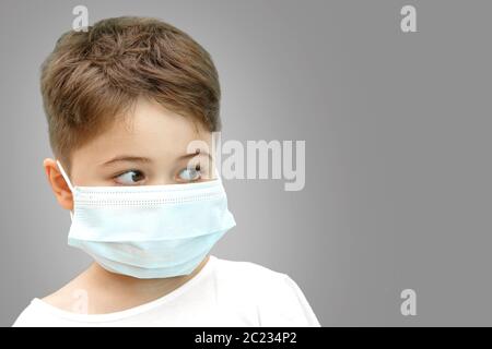 Peu Caucasian boy in medical masque sur fond isolé Banque D'Images