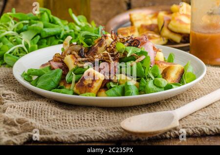 Avec gnocchi de pommes de terre salade d'été, du bacon et des oignons frits. Puis bouilli Gnocchi frits sur croustillant d'or à la batée Banque D'Images