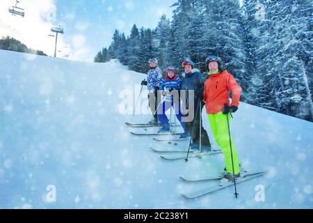 Groupe d'enfants adolescents de l'école de ski se tiennent sur la piste de ski près de la neige couverte de fermes dans les montagnes Banque D'Images