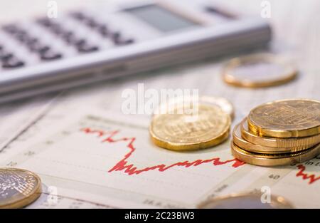 Pièces en euros et un graphique avec courbe rouge symbolisant la fluctuation des taux de change. Banque D'Images