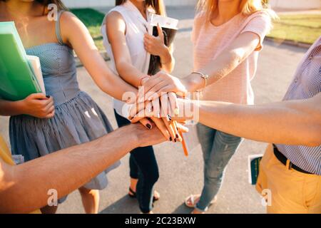 Les étudiants de l'équipe de jeunes adolescents mains empilés. Close-up Banque D'Images