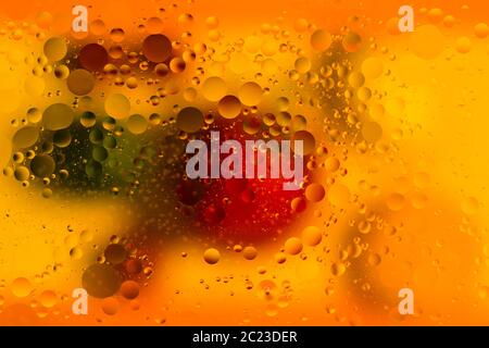 Image studio en intérieur de lumière abstraite et de couleurs capturées sur des gouttes d'huile dans l'eau, sur un fond coloré Banque D'Images