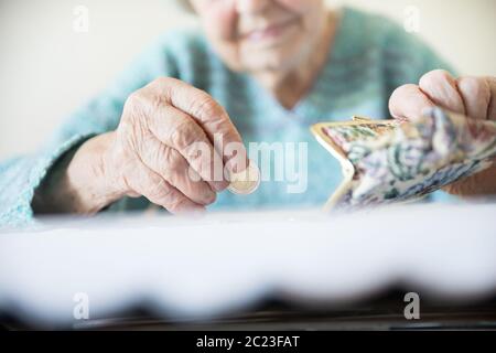 Photo gros plan détaillé de personnes âgées 96 ans womans mains restant de comptage de pièces dans son portefeuille de retraite après le paiement des factures. La non-durabilité o Banque D'Images
