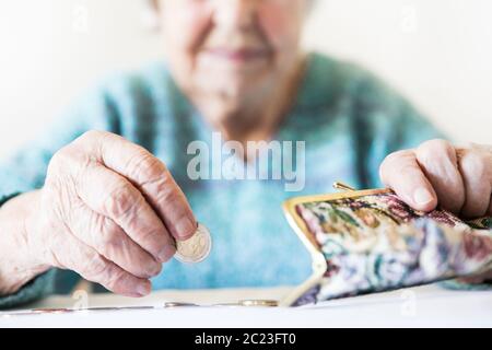 Photo gros plan détaillé de personnes âgées 96 ans womans mains restant de comptage de pièces dans son portefeuille de retraite après le paiement des factures. La non-durabilité o Banque D'Images