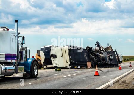 Cinquième véhicule de camping-car a été renversé sur l'autoroute avec un camion de chantier qui essayait de le sortir de la route et deux semis garés à proximité et des cônes de circulation qui garaient la circulation Banque D'Images